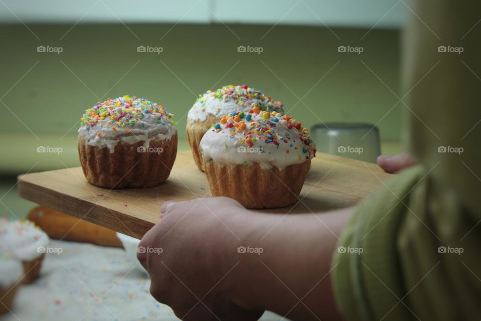 baking muffins for a holiday dinner. White icing on the cake is sprinkled with colored confectionery topping. Close photo on the theme of Easter and the resurrection of Jesus Christ.