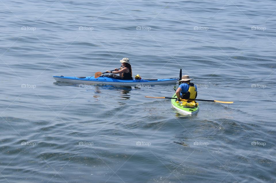 Kayakers paddle in the Puget sound of West Seattle, Washington during a kayaking competition.