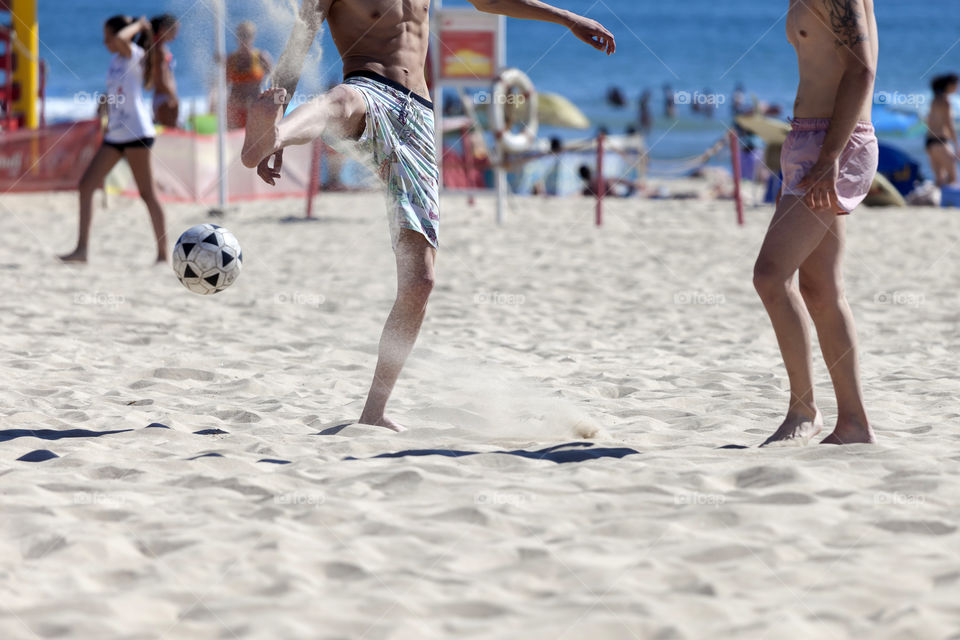 Playing football at the beach