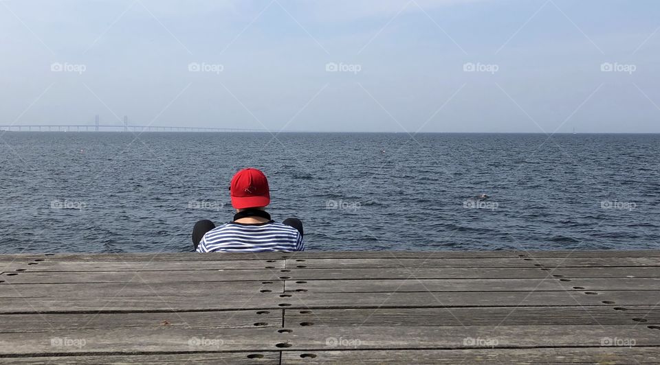 Red cap relaxing by the ocean