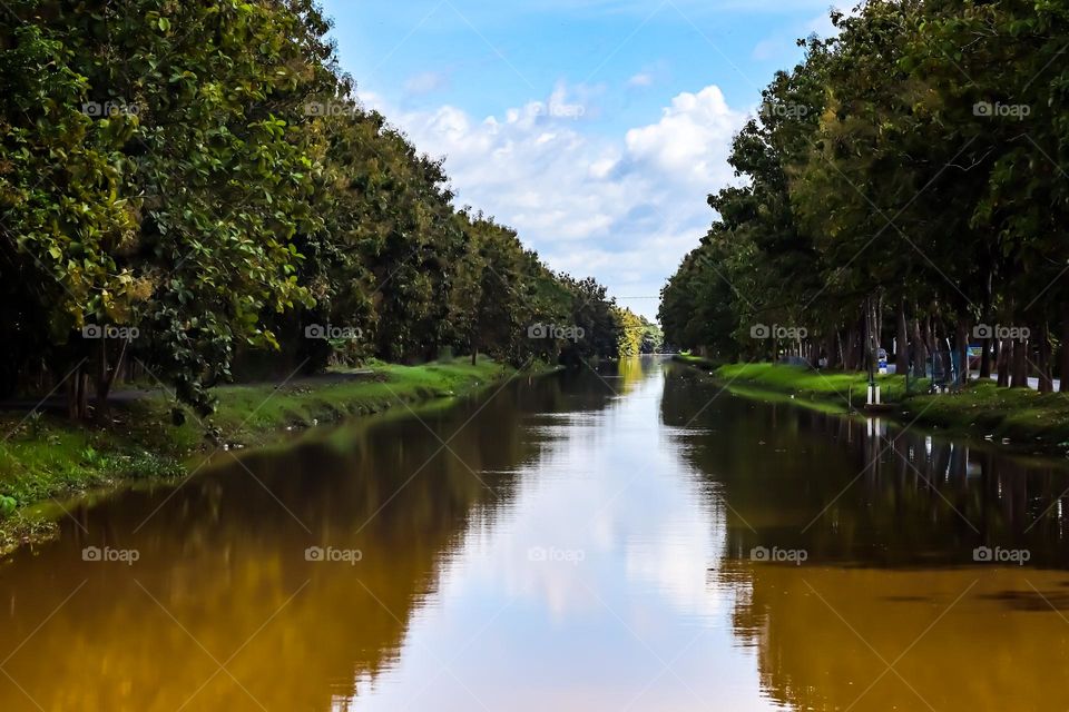 Triangular share of reflection of the cloudy blue sky on the water surface