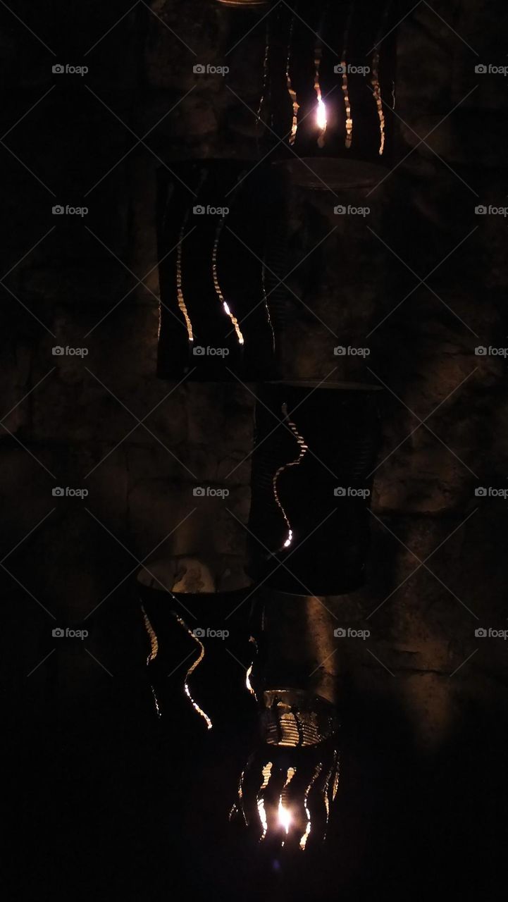 Flames illuminations by night along old wall = without electricity ...