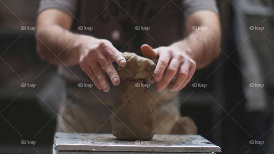 Potter hands measuring clay