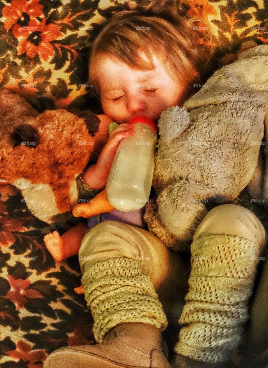 Toddler Taking A Nap. Baby Girl Drinking Milk From A Bottle
