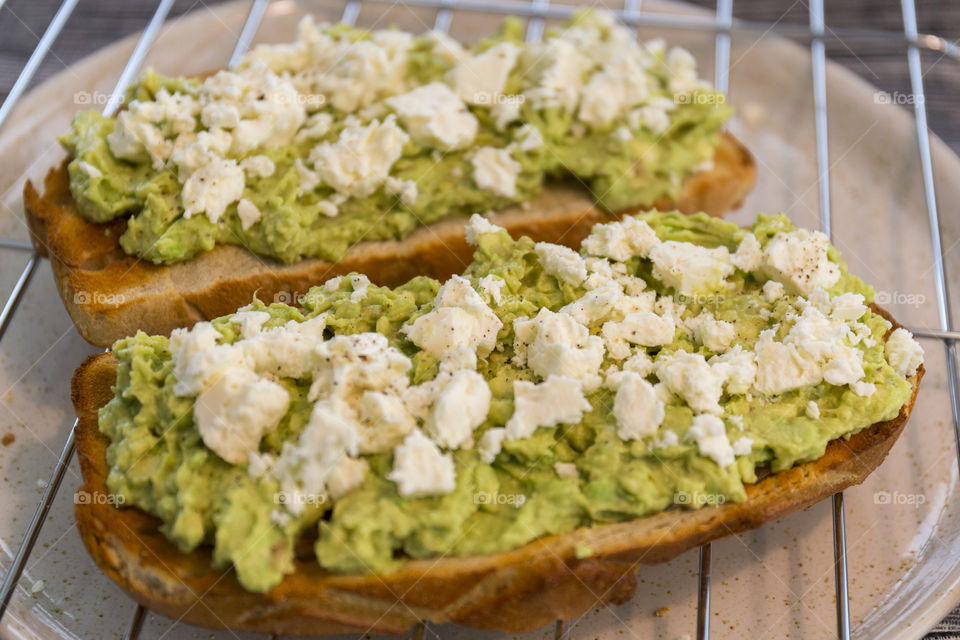 Preparing healthy breakfast - avocado feta toast 