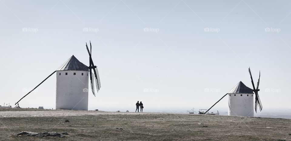 Couple take a walk close to old traditional windmills 