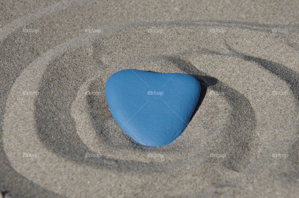 Blue heart on the sand