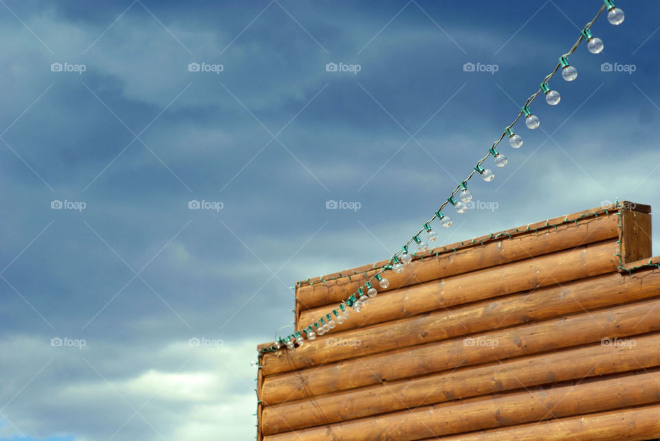 Wooden log cabin against stormy sky