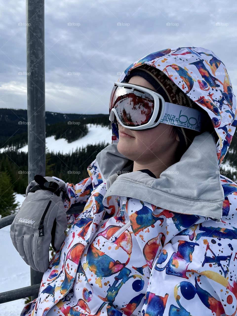 A female snowboarder takes a relaxing ride up the mountain on a ski lift at White Pass Ski Resort, Washington State 