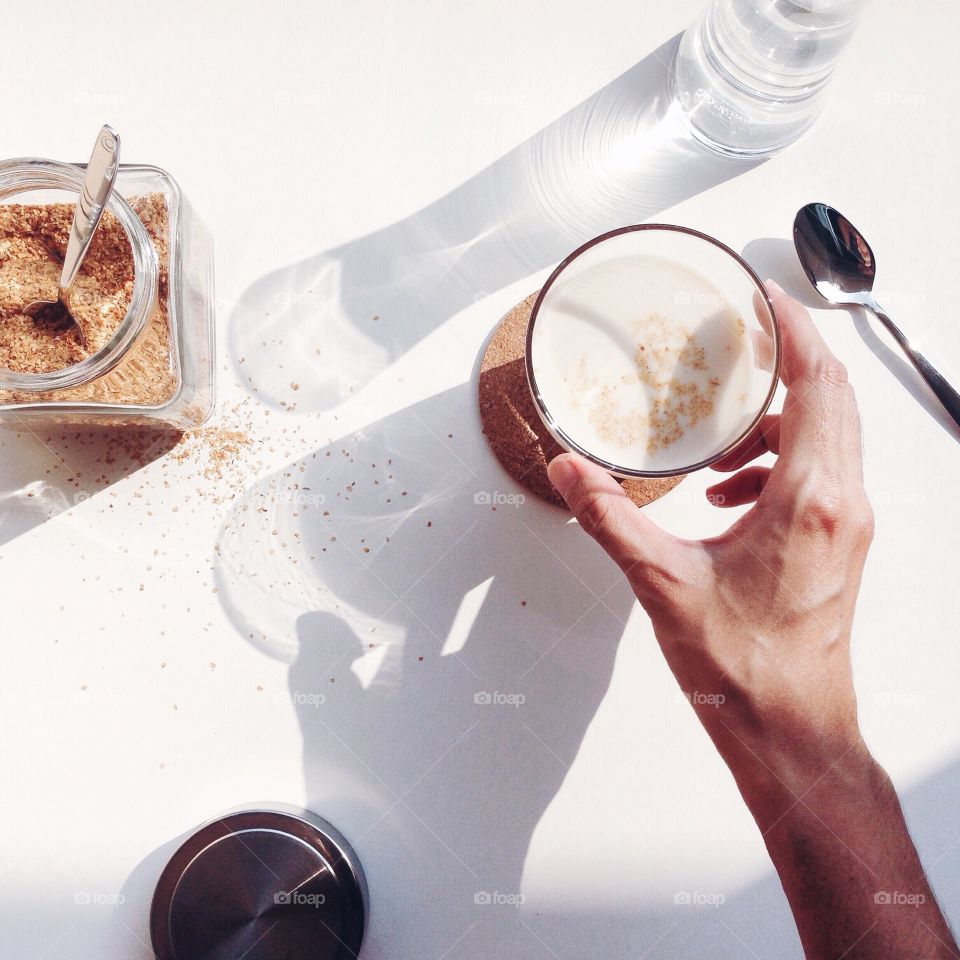 Person's hand holding soy milk