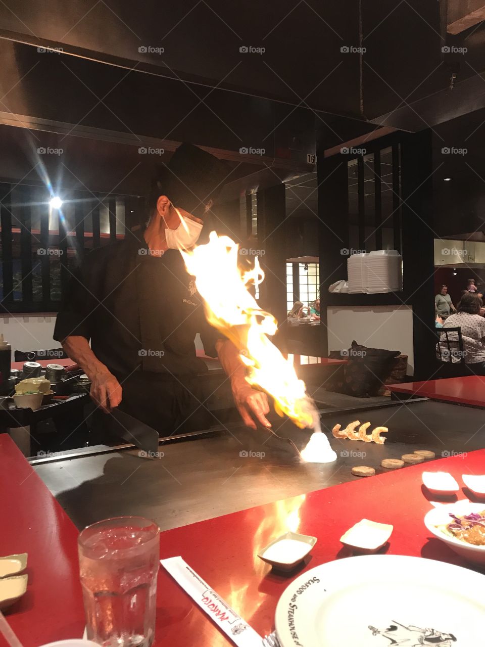 Server at a Japanese restaurant with flame traveling toward his face