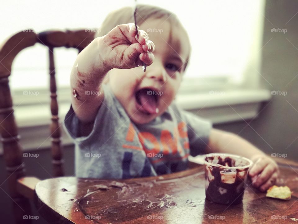 Messy eater, toddler eating pudding 