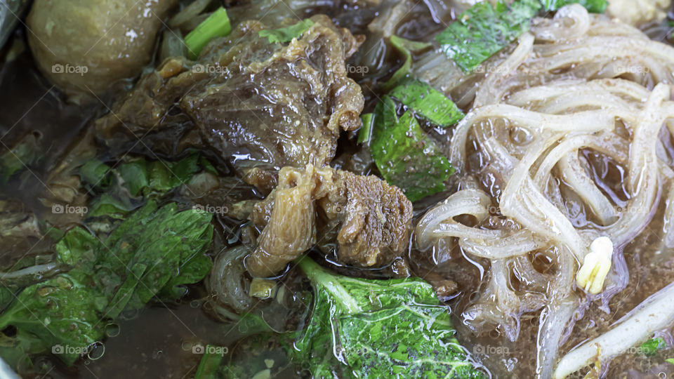 Spicy noodle soup with beef , meatballs and vegetables.