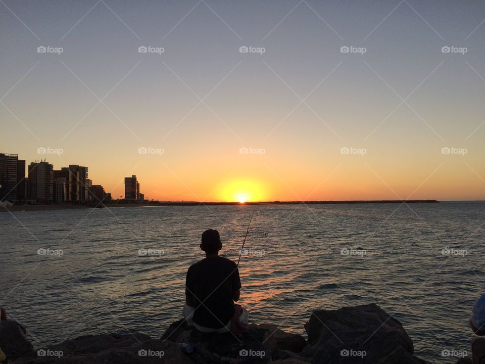 Man fishing at sunset in Fortaleza, CE - Brazil