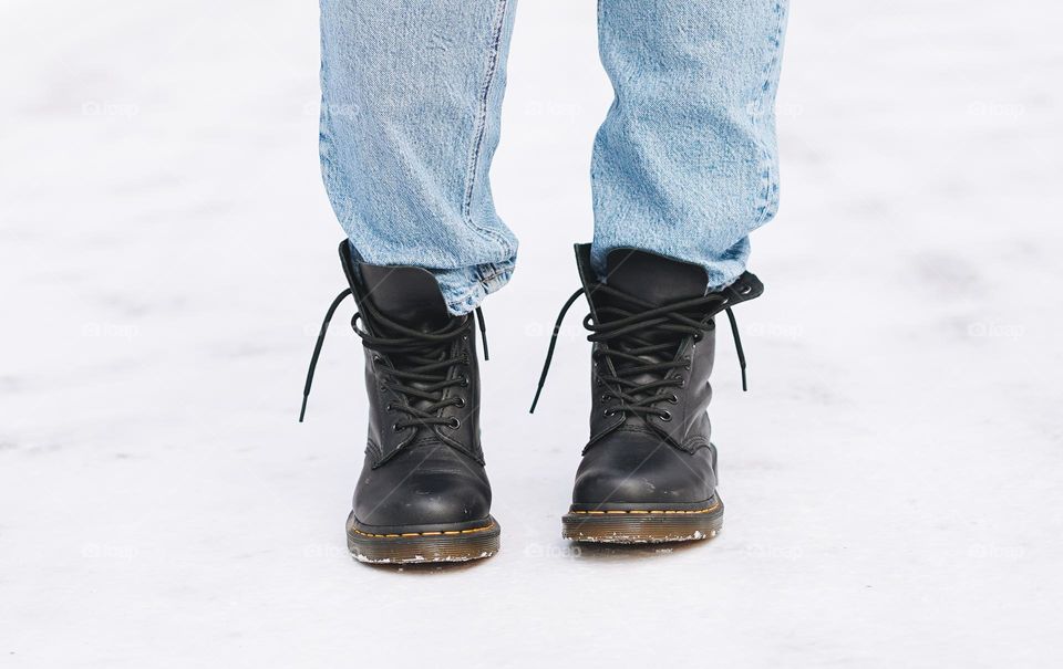 Young woman in black Dr. Martens boots in winter forest