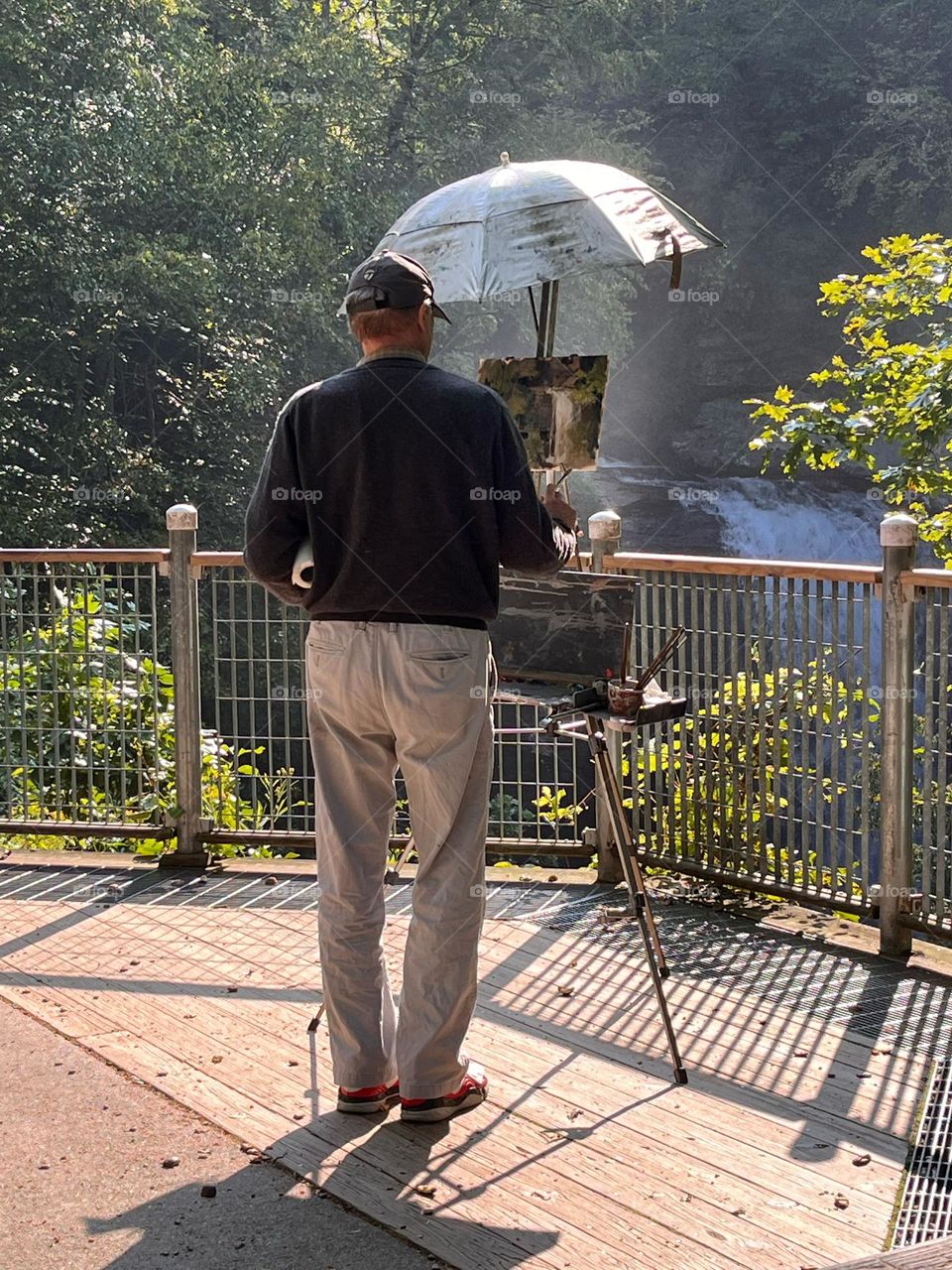 Artist painting a waterfall scene plein air 