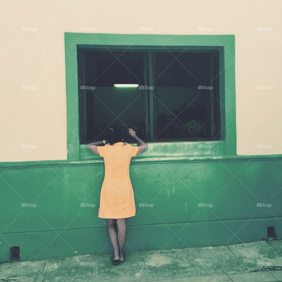 Flower order. Lady order flower from window flowershop in Havana