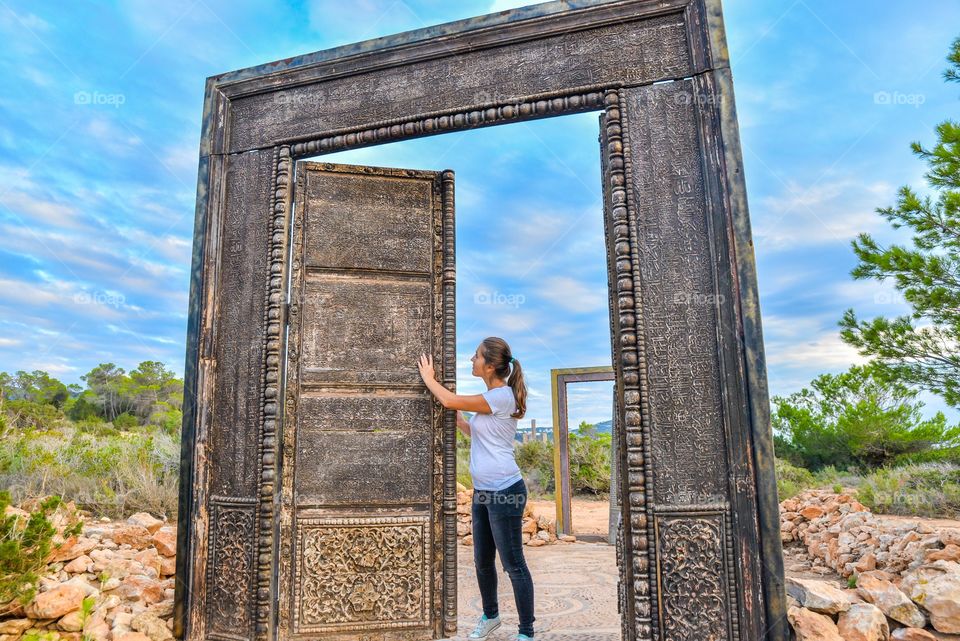 Woman standing near ancient door