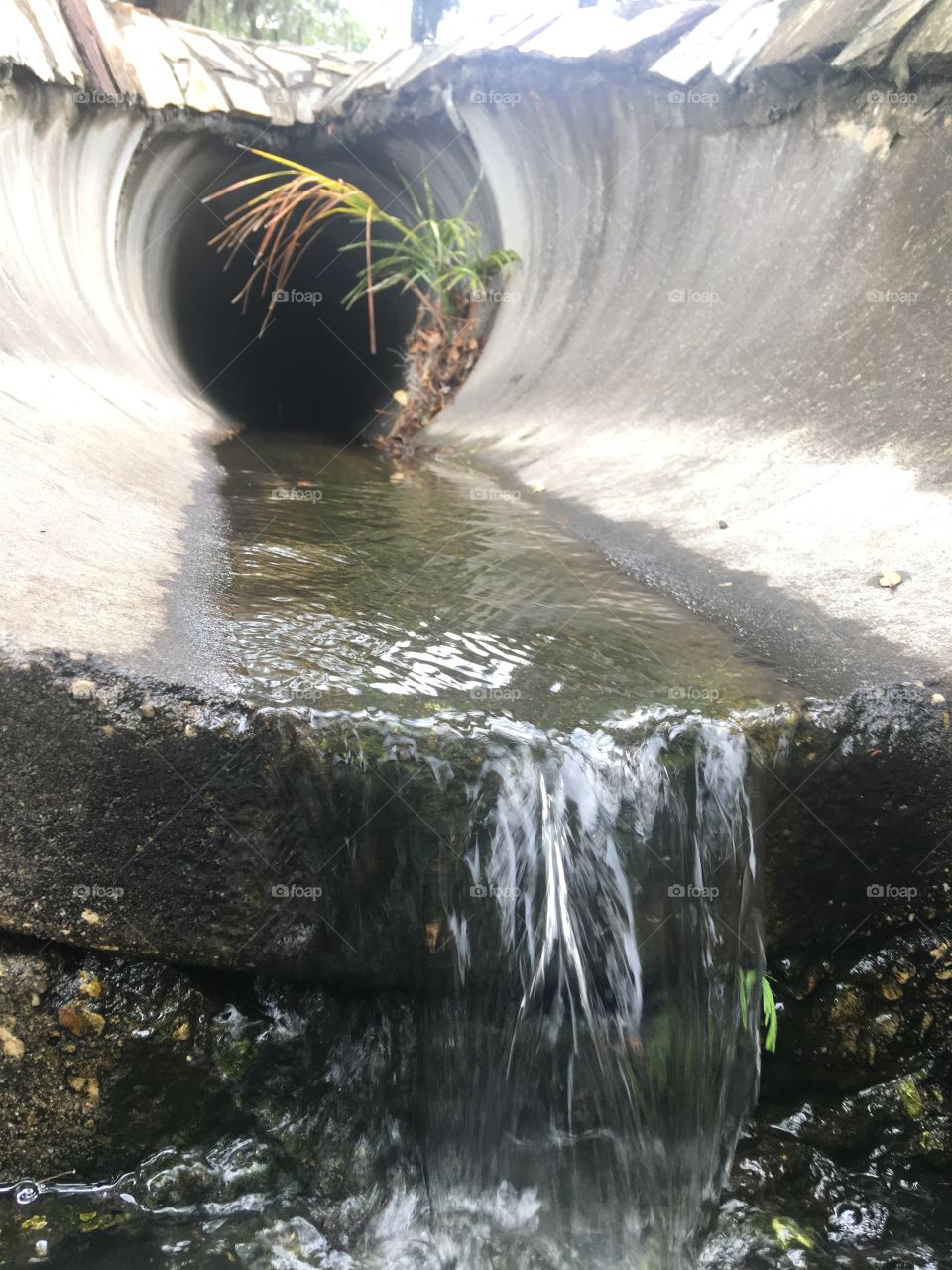 Water running through a pipe outdoors 