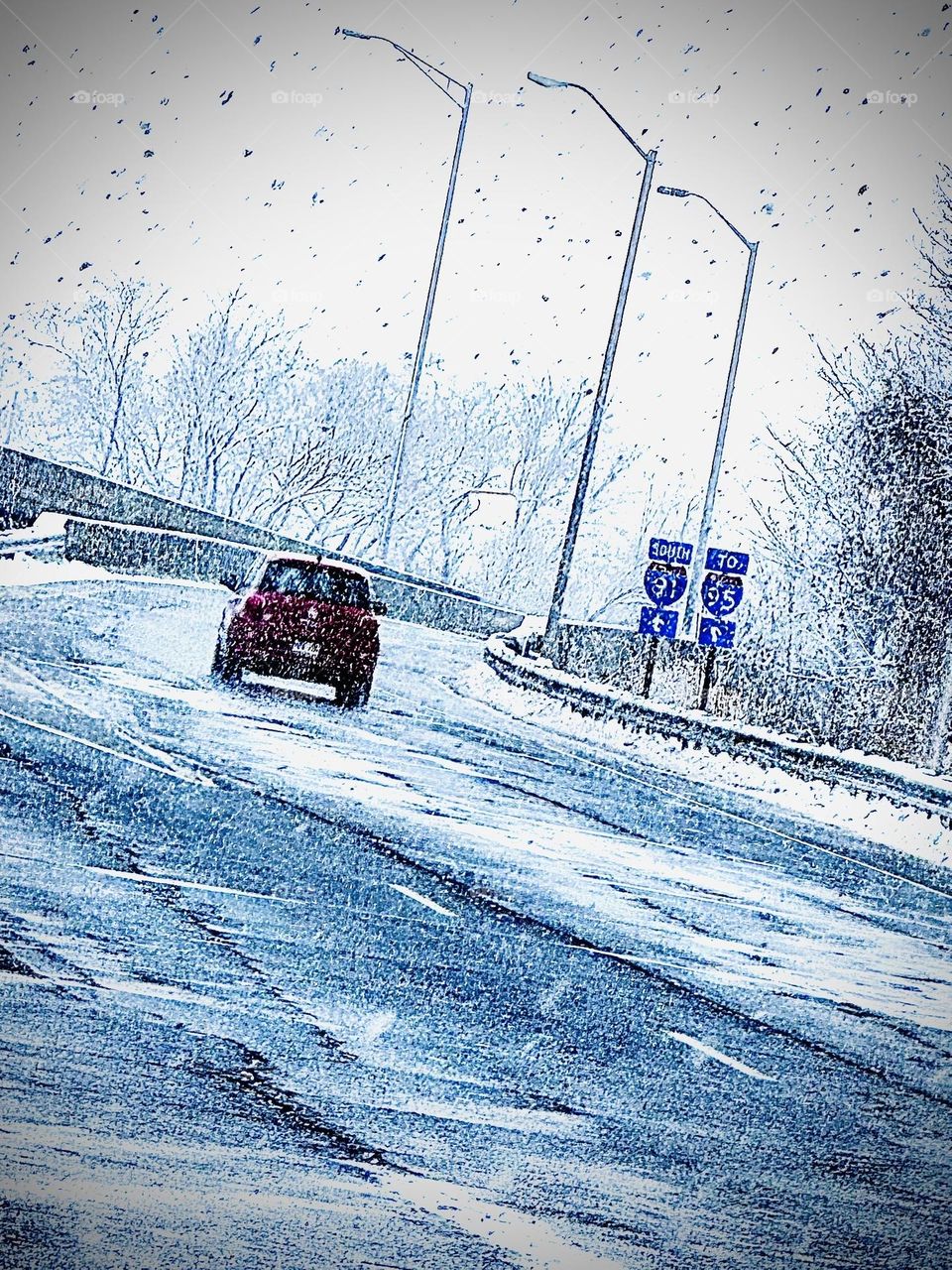 Lone driver braving snowstorm on empty highway 