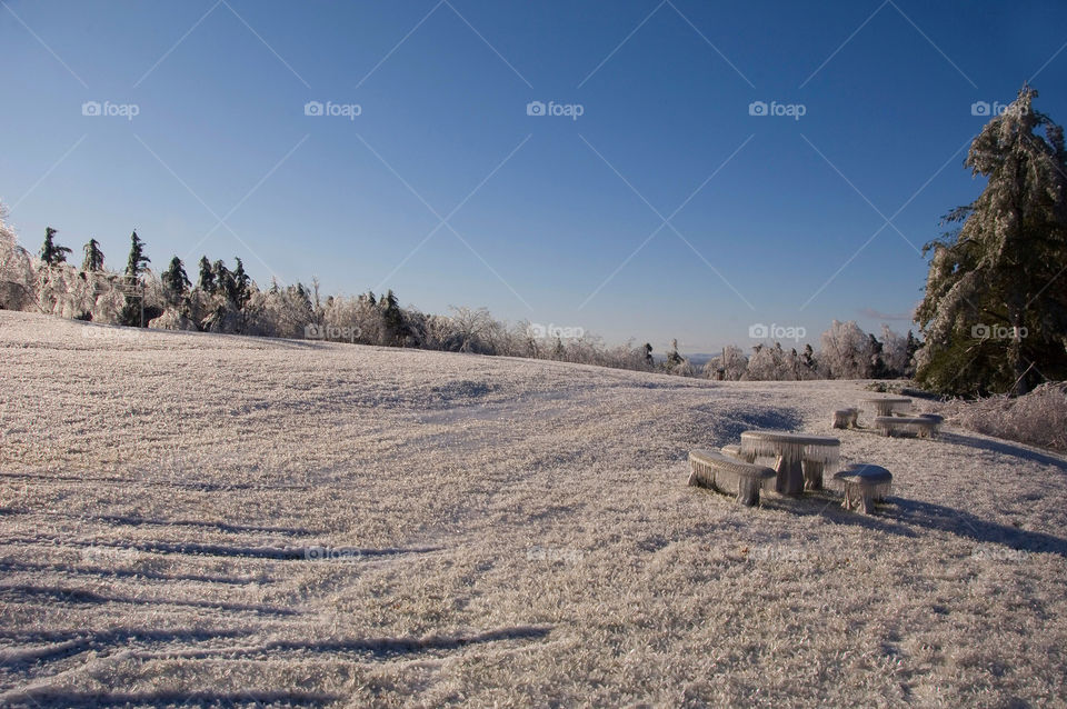 And ice encased picnic table amongst and ice encased landscape after