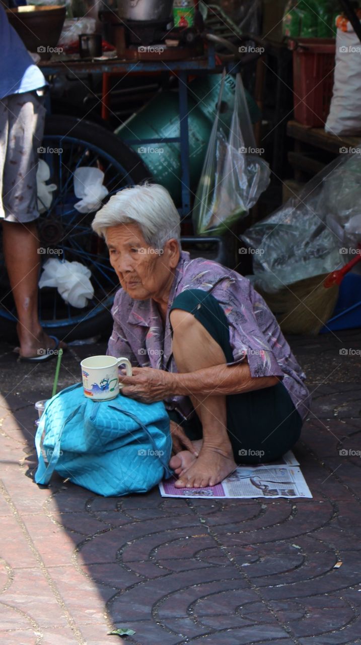 Can you spare? Senior begging at Chinatown Bangkok Thailand 