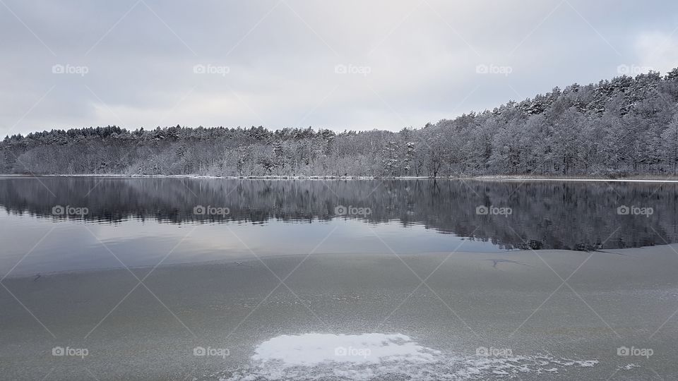 Winter, forest reflection on lake and ice - vinter skog reflektion sjö is Sverige