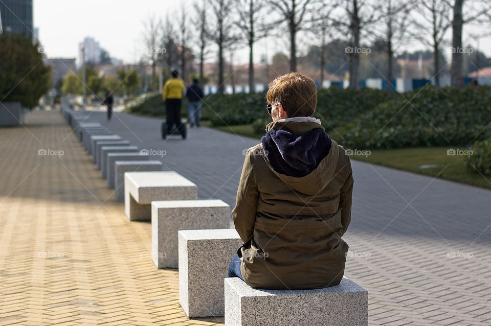 Person looks at other people enjoying leisure 