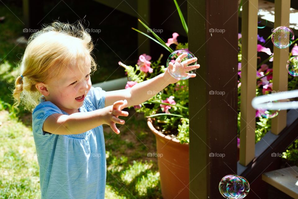 Baby chasing bubbles
