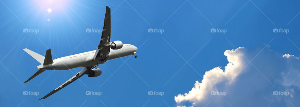 Commercial airplane flying above beautiful sky in dramatic sunlight.Travel and transportation concept.