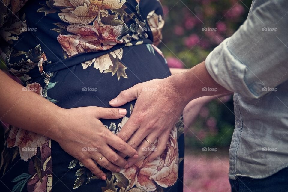 Man puts his hands on his wife’s pregnant belly 