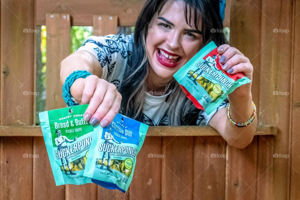 A vibrant young lady is sure enjoying her pickles! 