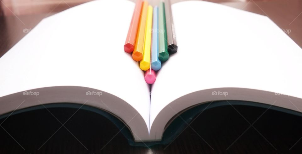 colorful crayons on an open notebook