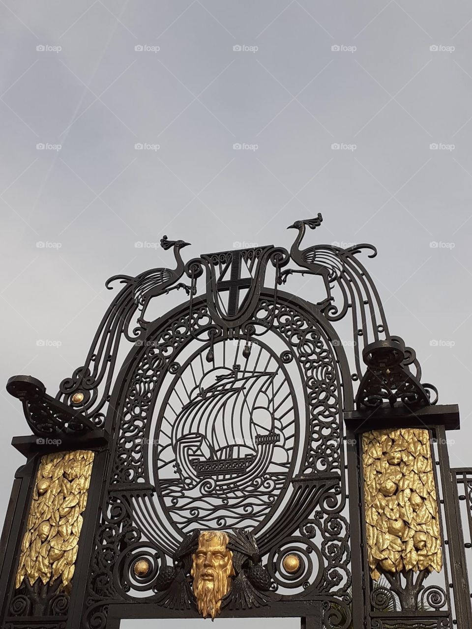 Une porte dans un parc de Marseille, au dessus deux grues couronnées sont représentées.
