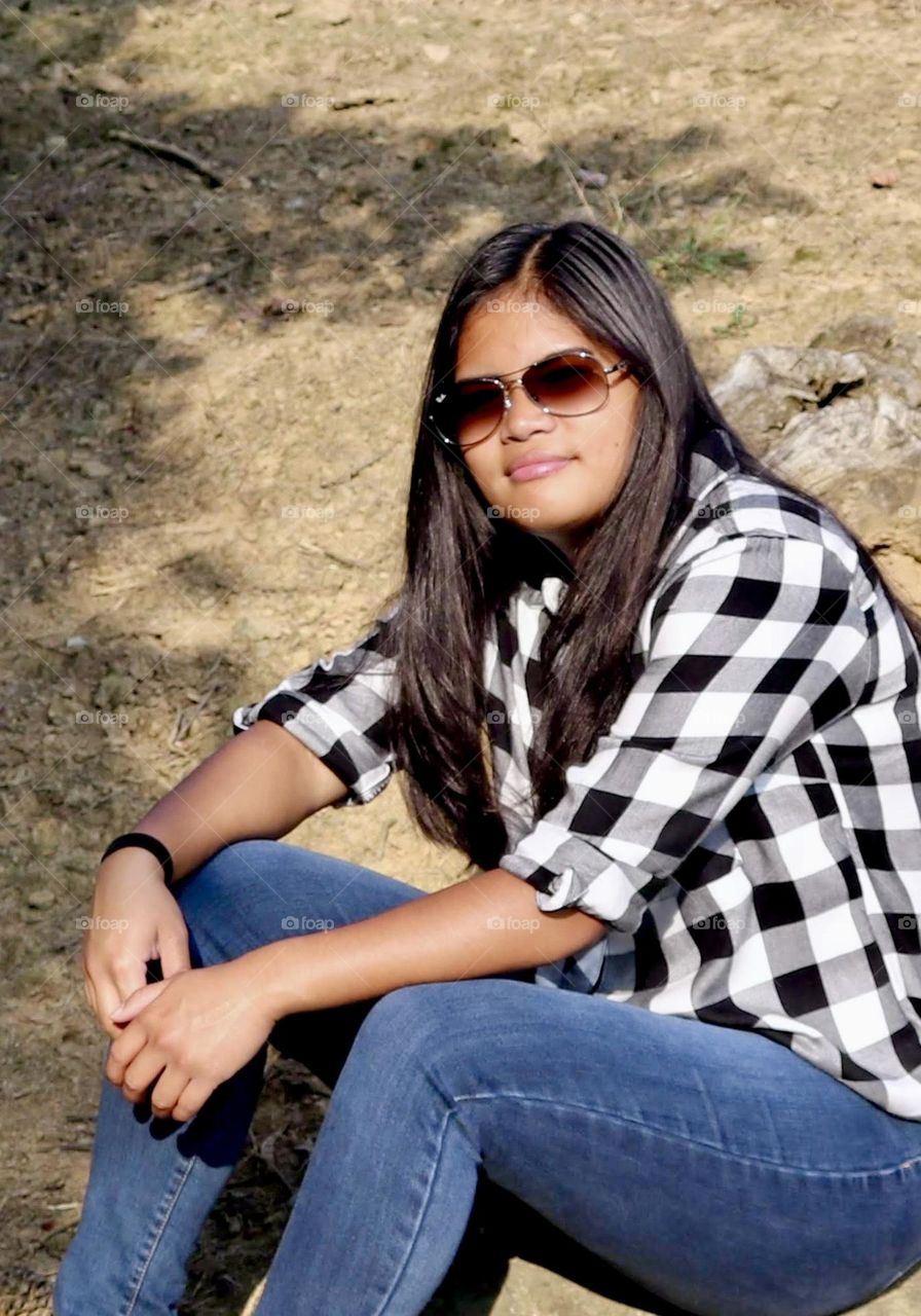 Girl with long black hair wearing sunglasses 