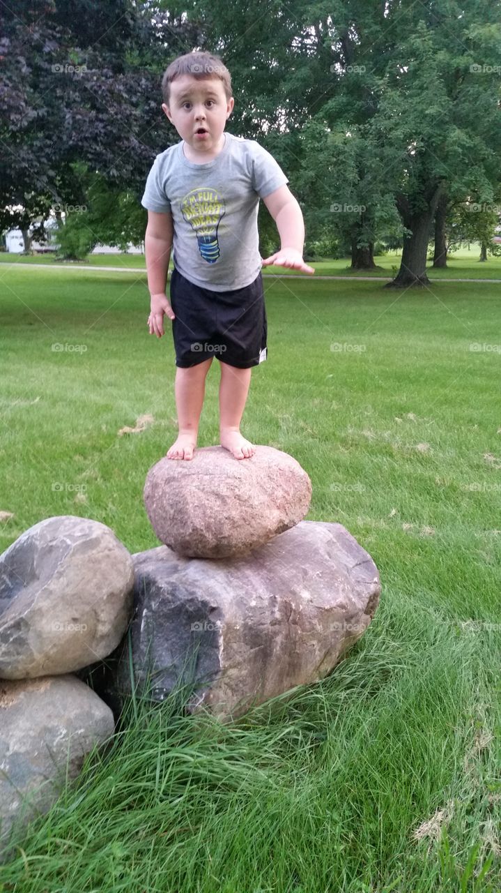 Boy standing on rocks in park