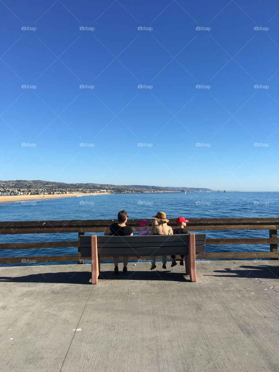 Sitting on a bench looking into the ocean. 