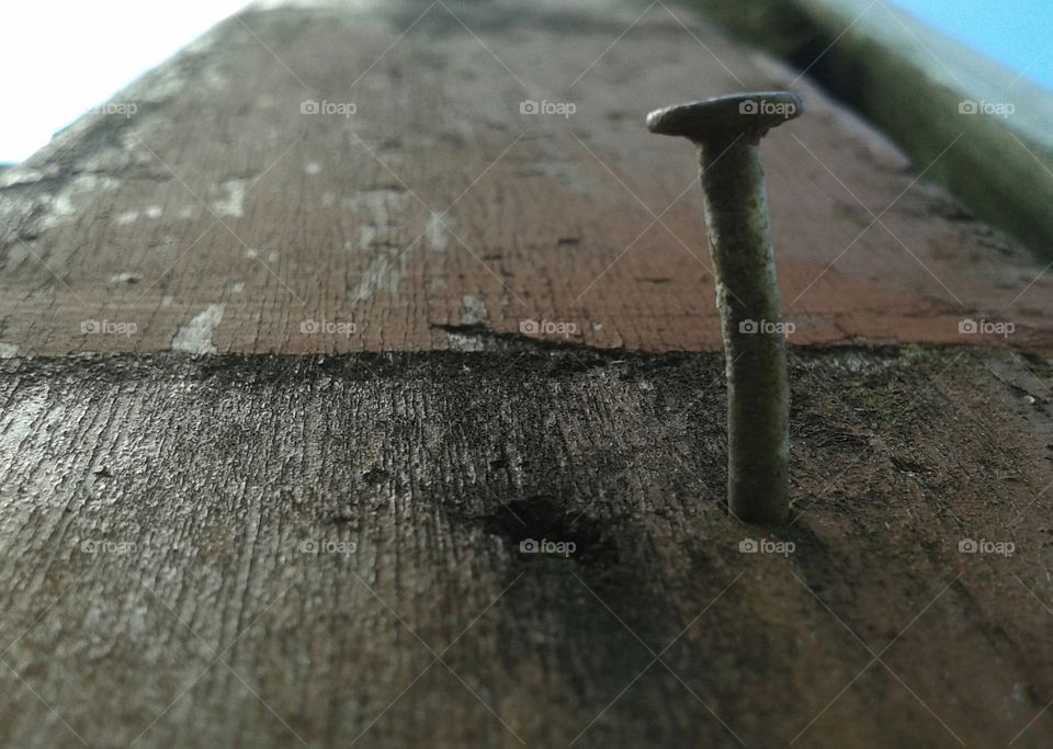 old nail in a wooden support beam