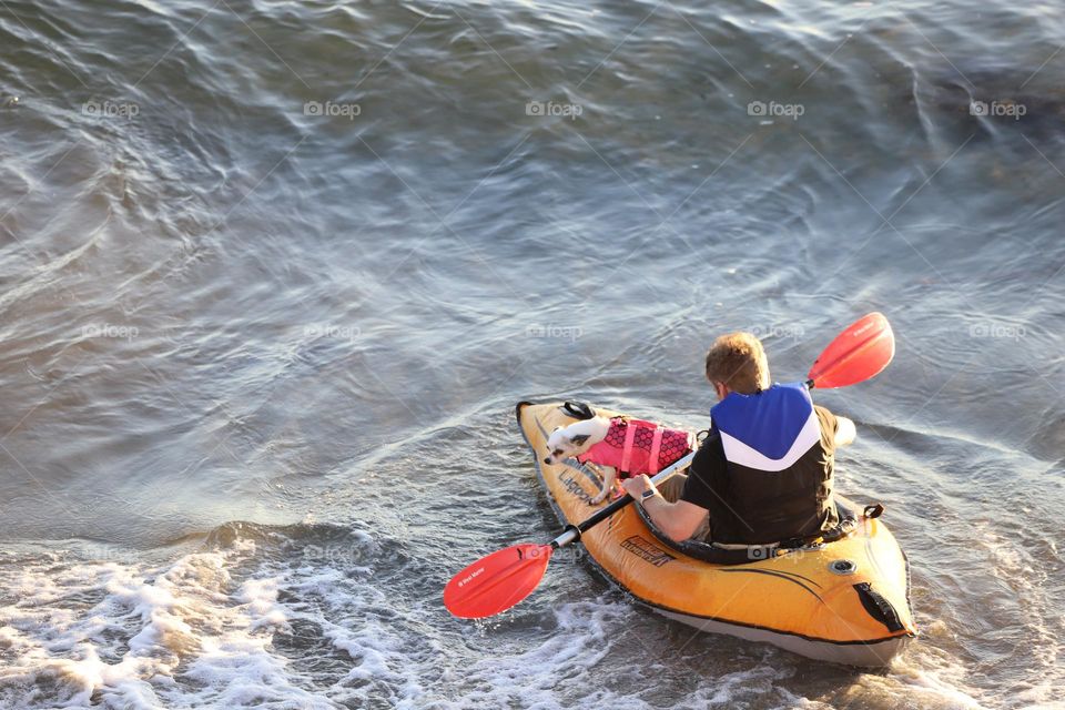 The kayak , the man and the the little dog