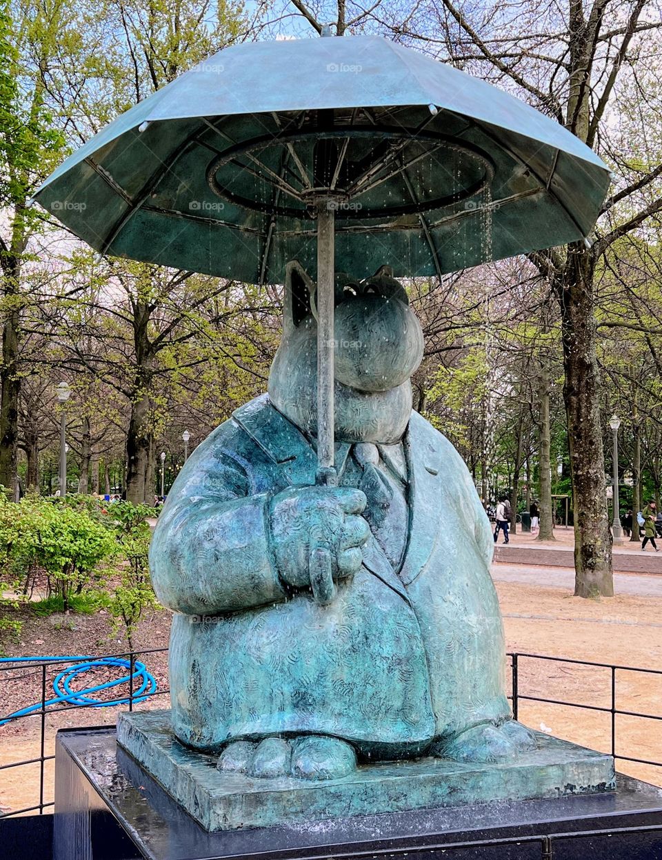 Cartoon creature Le Chat under the umbrella with flowing water 