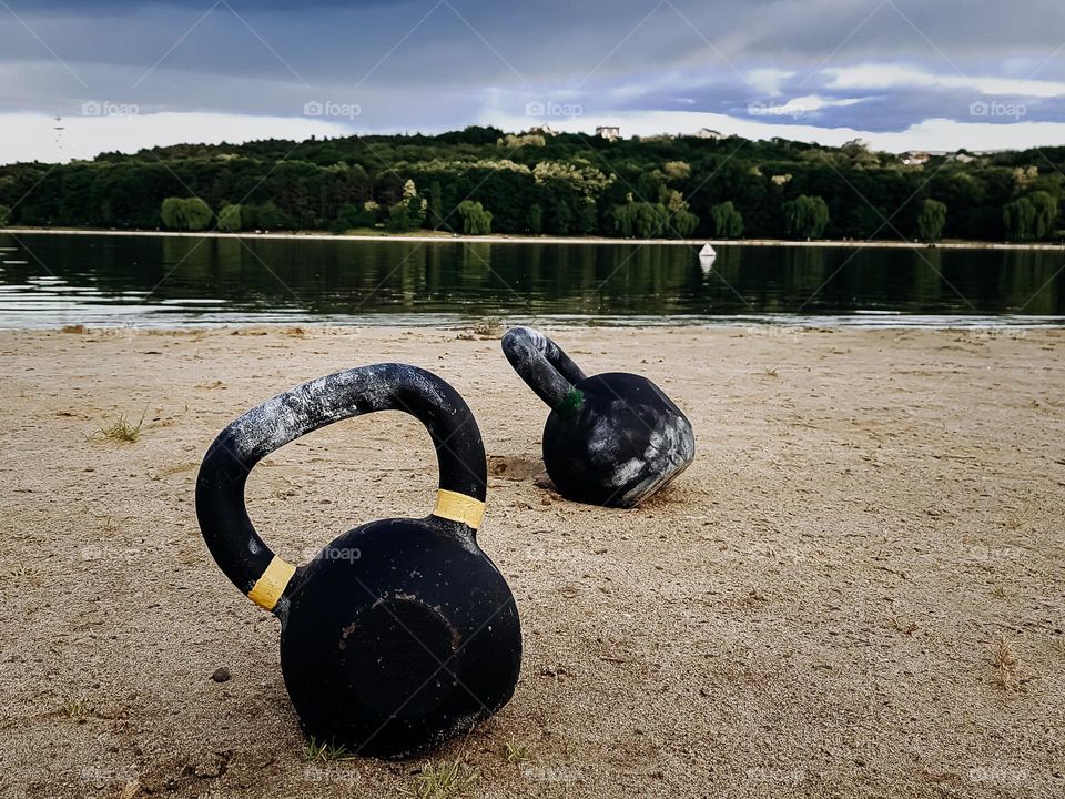 two kettlebells on the beach