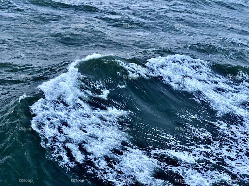White and blue Foamy waves on the Atlantic Ocean off the North Carolina Coast. Spring time. 