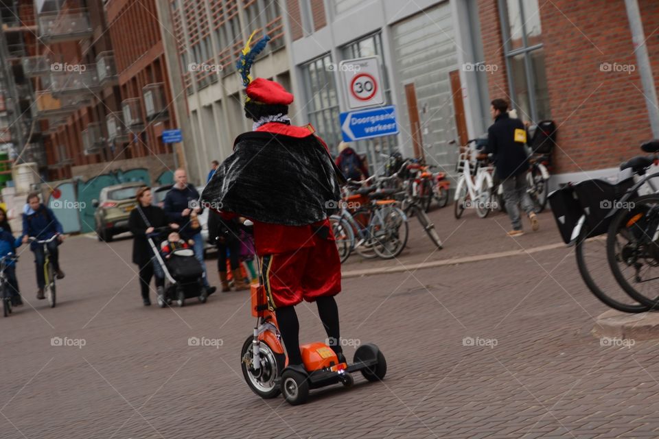 Black Piet driving on the street on a Segway in Scheveningen during the welcoming of Sinterklaas

Zwarte piet rijd op een Segway in Scheveningen tijdens het binnenhalen van Sinterklaas 