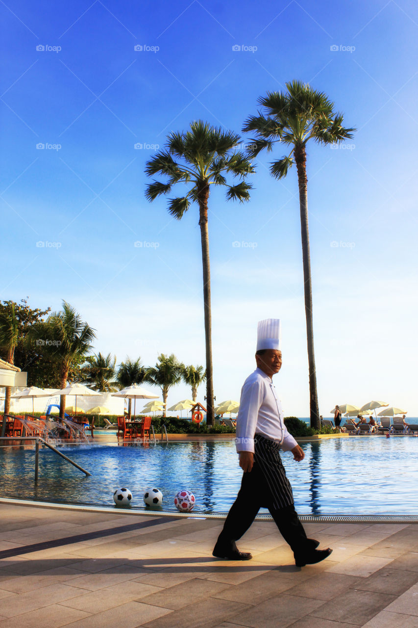 Time for lunch. Chef walking by the pool