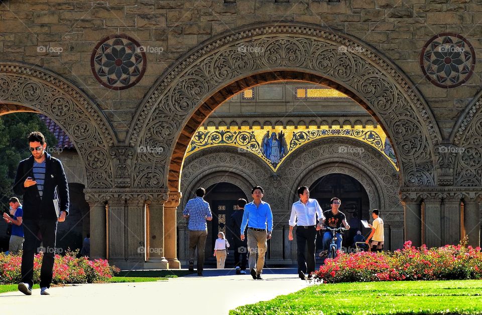 Pedestrians Walking Under An Archway