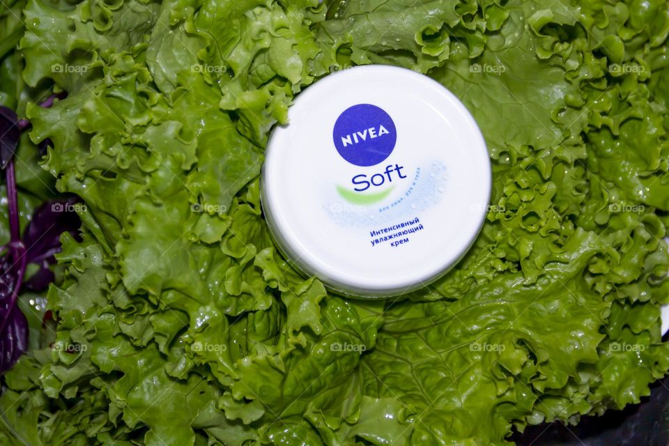 Cosmetic product, Nivea skin care cream on the background of fresh salad with water splashes.