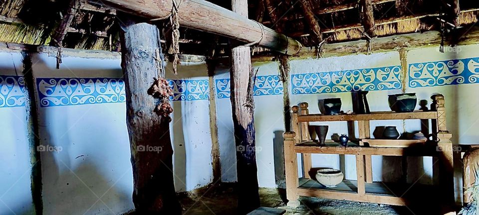 “Gabreta” is a small Celtic village newly erected after ancient model near the township of “Ringelai” in “Bavaria”. The fabric wall coverings display a Celtic band, there is a wooden loft structure and shelves with pottery. 2023. Hypnotic Productions