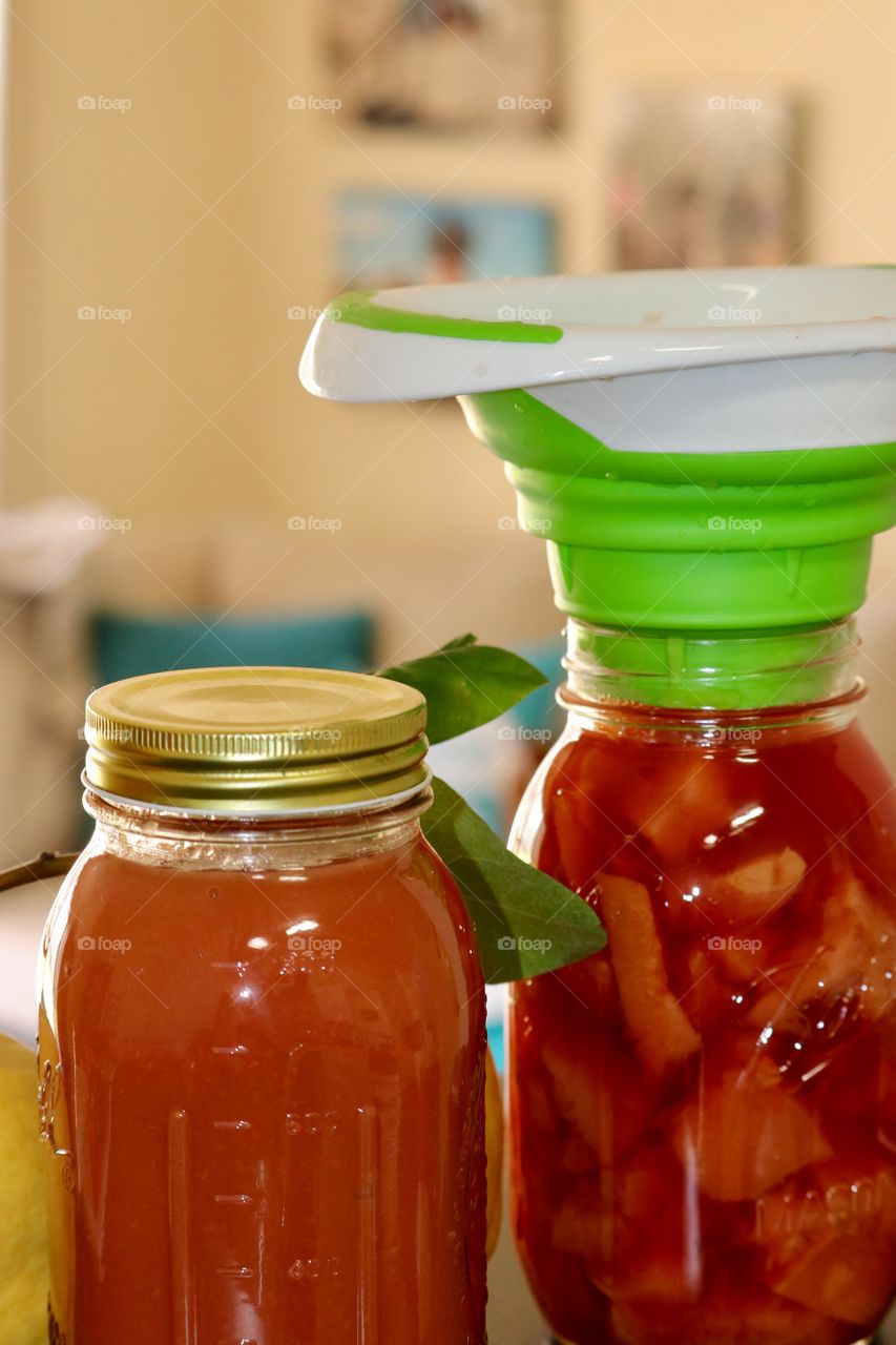 Preserve jar funnel, filling the jars with homemade quince fruit preserves and sauce 