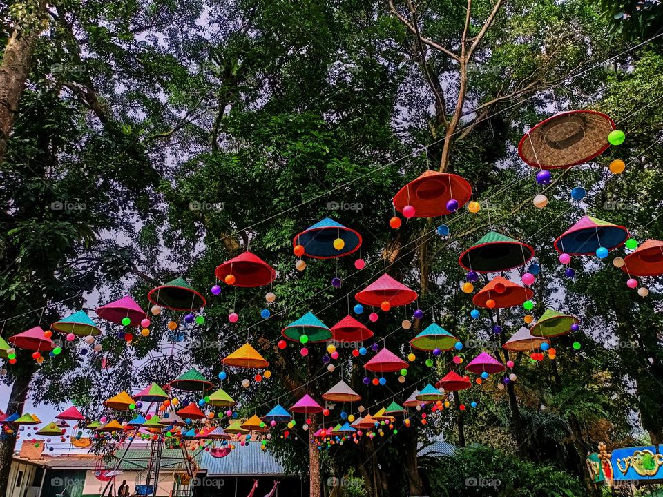 In preparation for the festival, umbrellas are hung on a rope tied between the poles to enliven the event