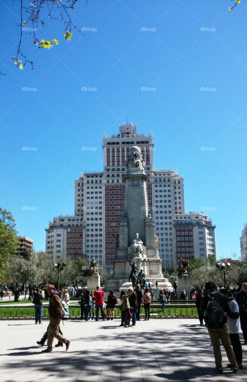 Beautiful building in Madrid, Spain behind a nice statue